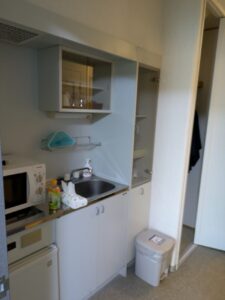 客室入口に設置されたシンクとキッチン。電子レンジや冷蔵庫が完備された、エンゼルグランディア越後中里の便利な客室設備