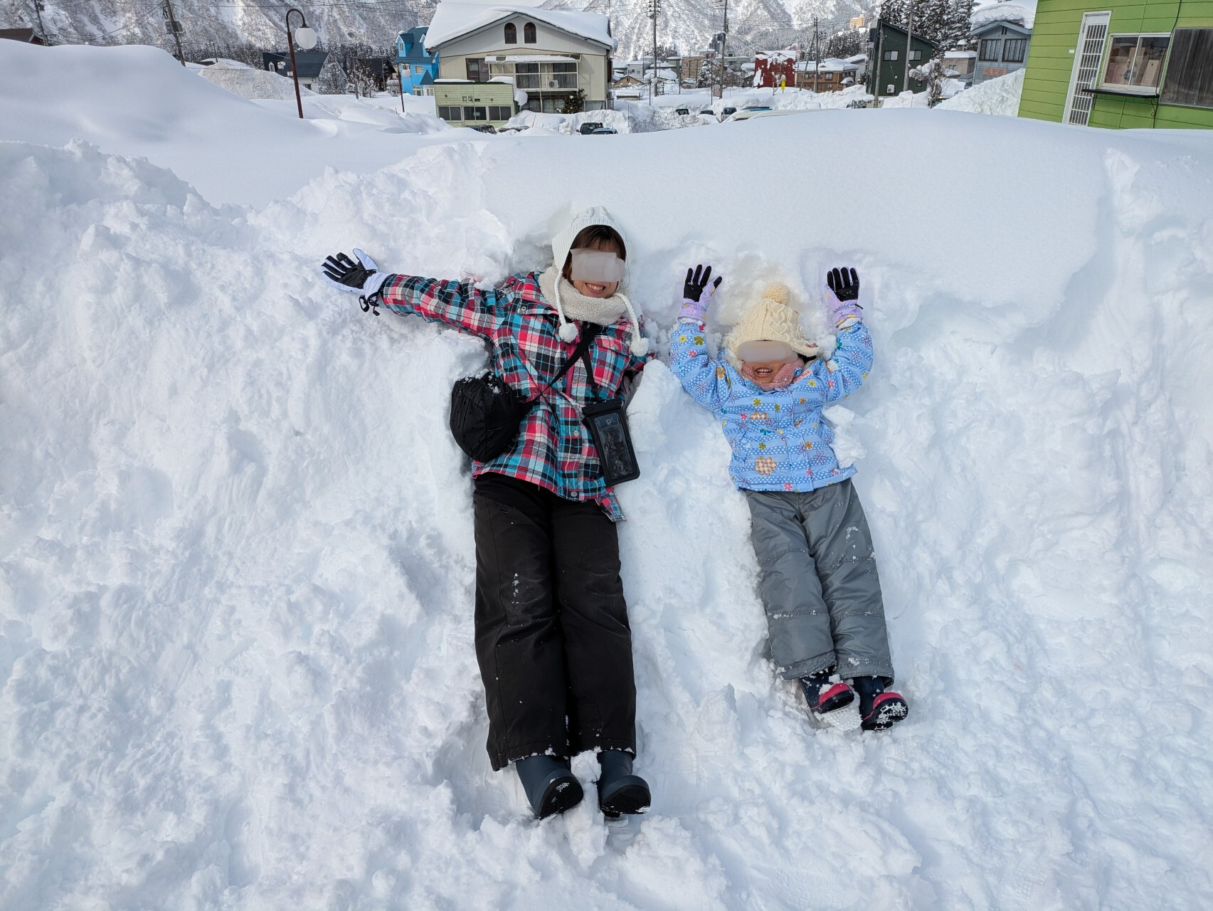 雪の上に寝転ぶ親子