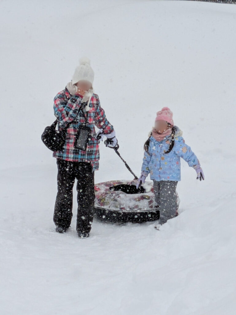 スノーチューブで滑る親子