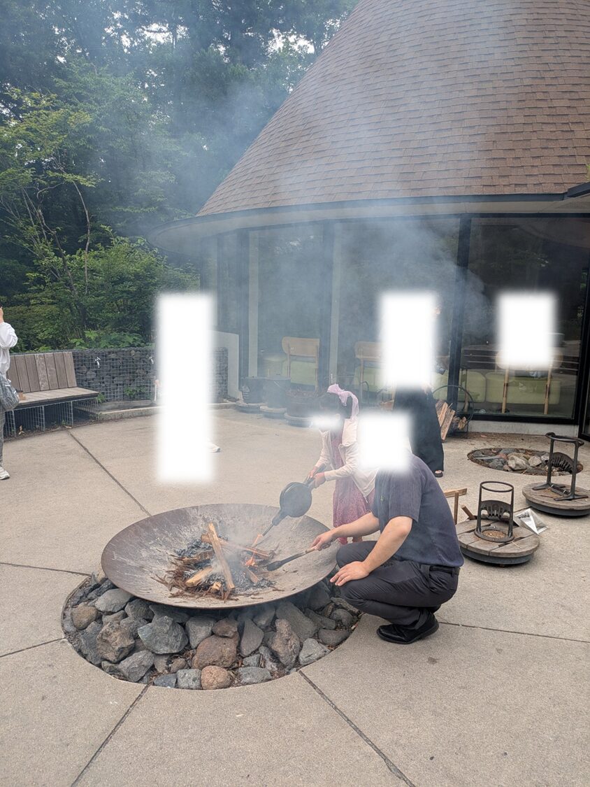 ふいごを使って火を大きくする子供