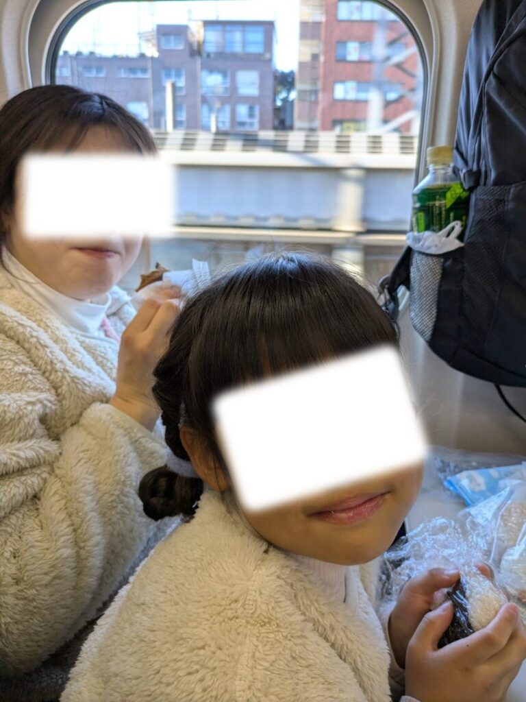 新幹線でおにぎりを食べる子供