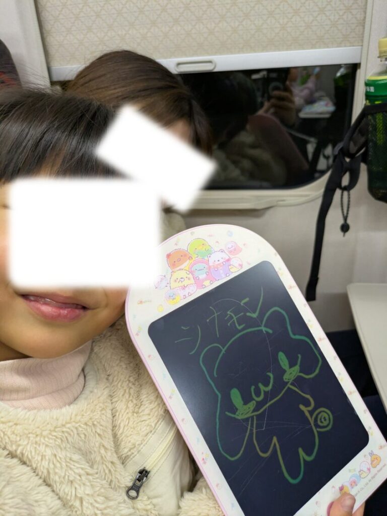 新幹線でお絵描きする子供