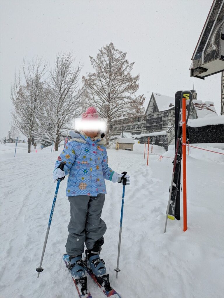 雪山を前にスキーを履いて立つ5歳の娘