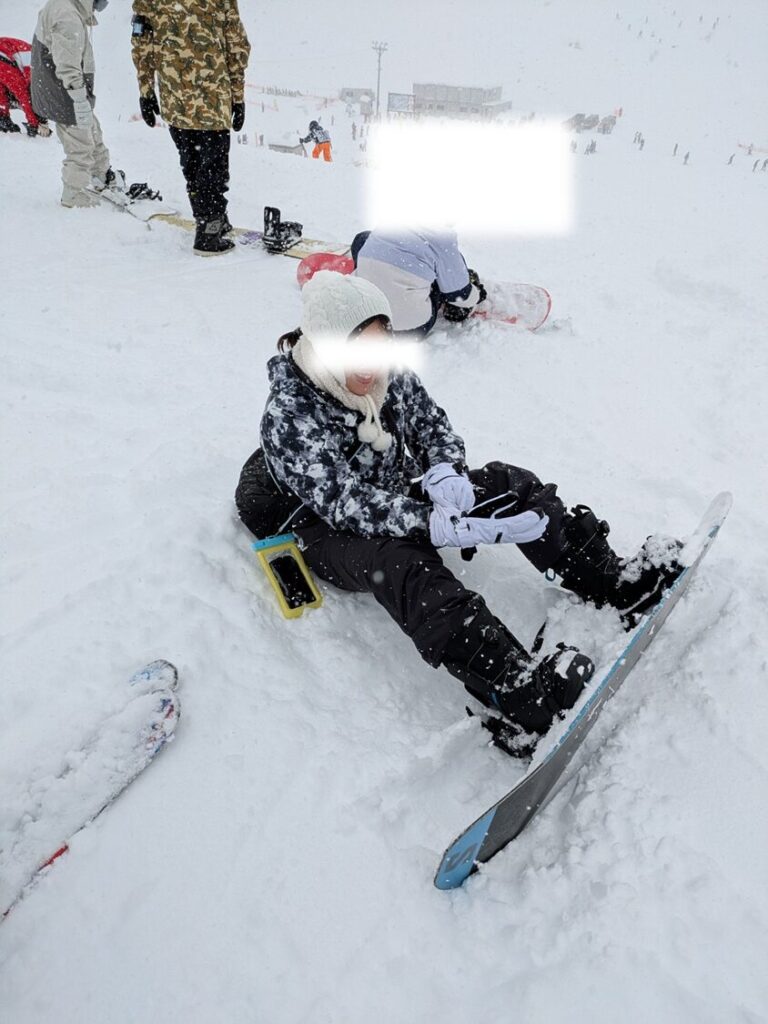 ゲレンデでスノーボードを持つ女性