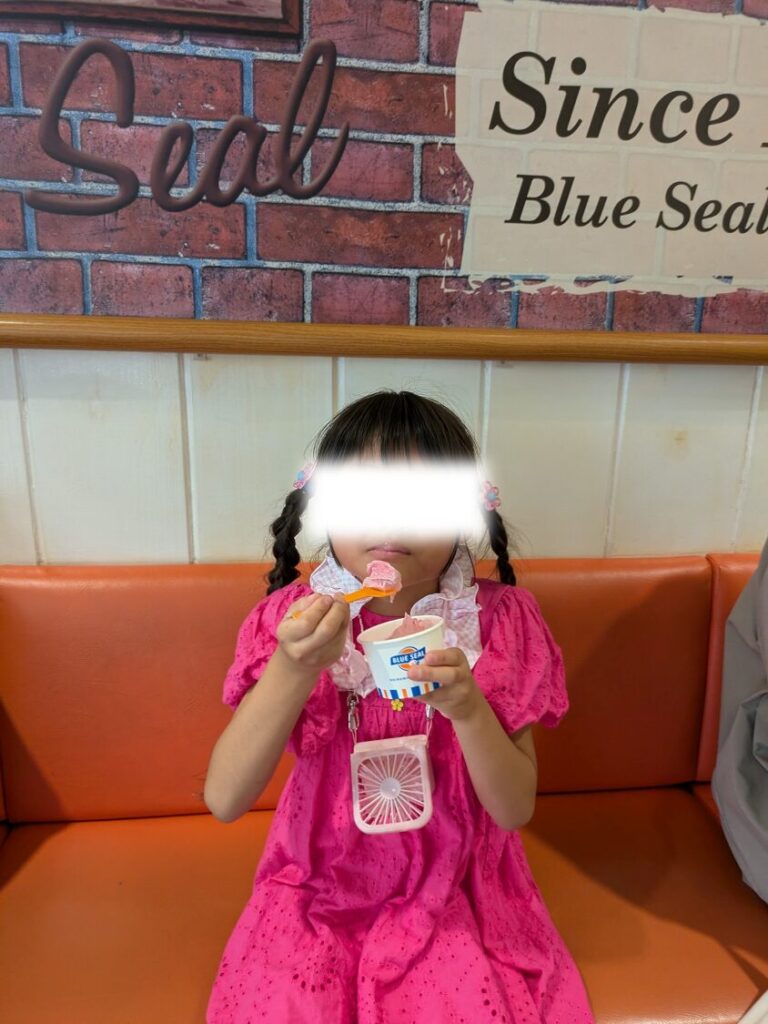 国際通り沿いのブルーシール（BLUE SEAL）店舗前でアイスクリームを手に笑顔を見せる子ども