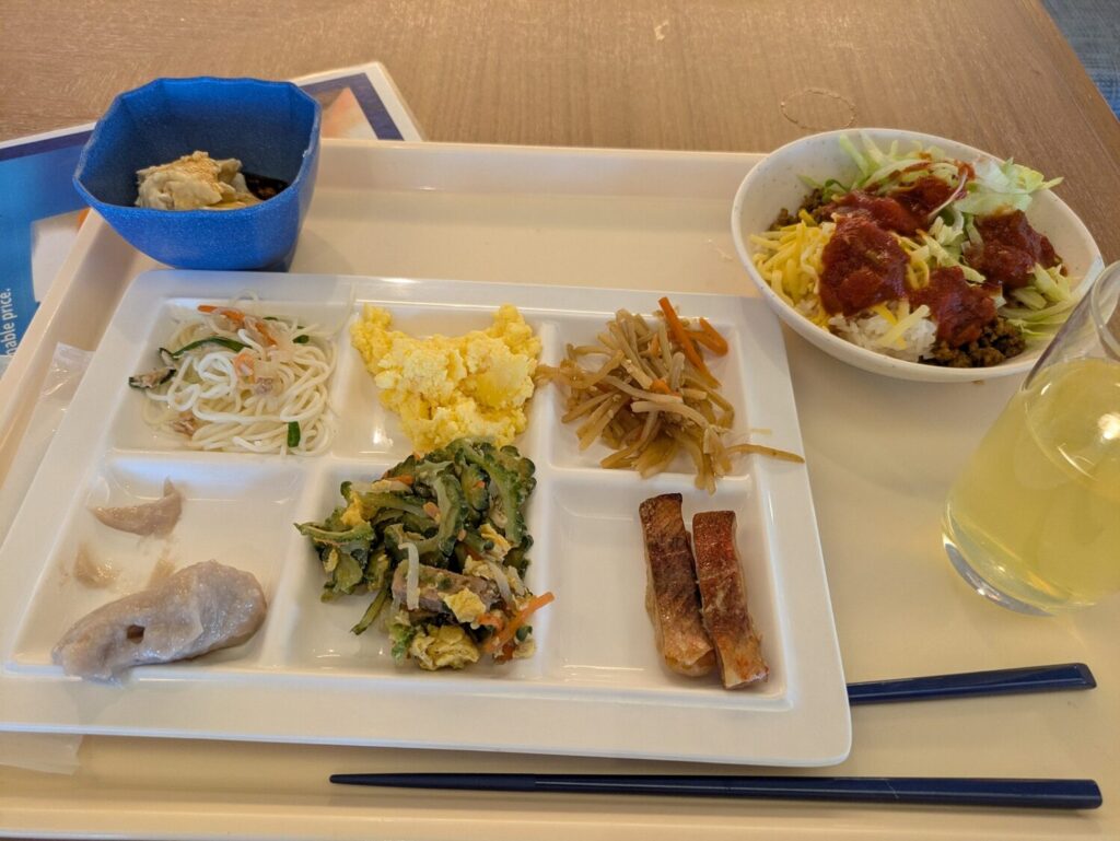 ゴーヤチャンプルーやタコライスなど沖縄料理が盛り付けられたホテルの朝食バイキング
