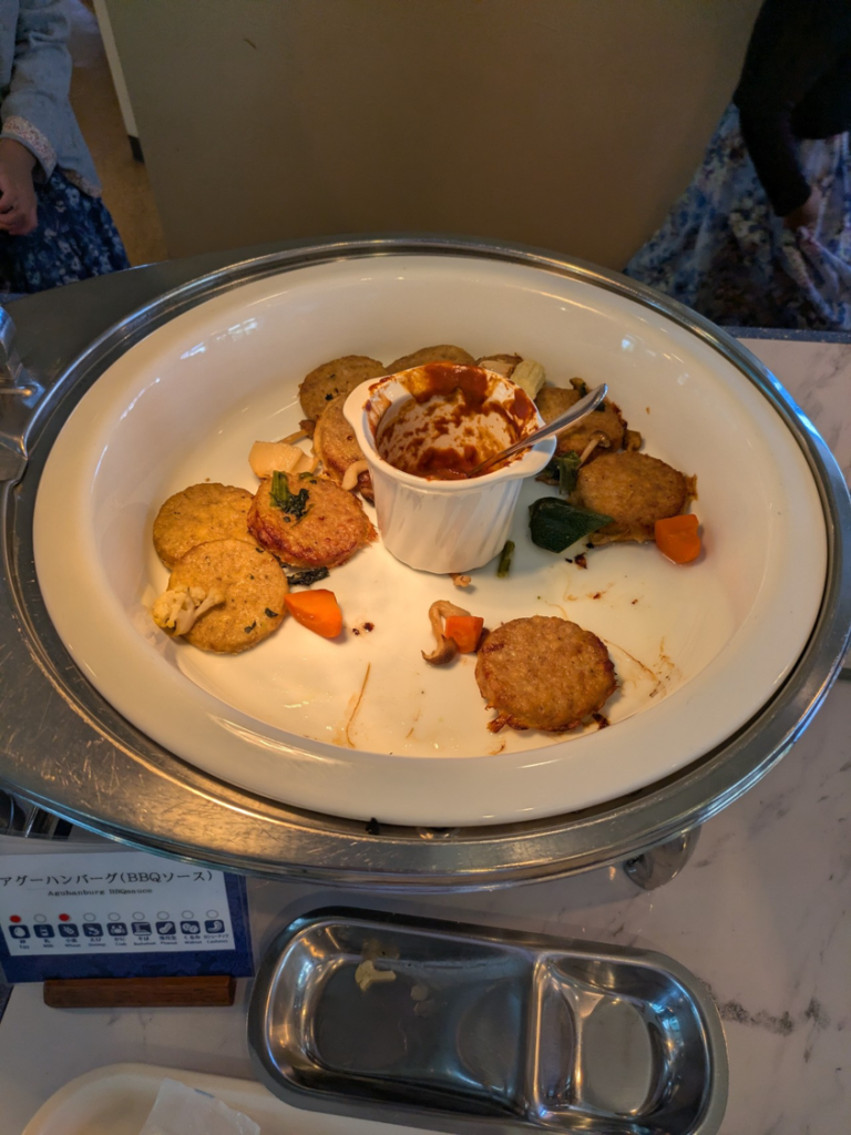 リザンシーパークホテル谷茶ベイのランチバイキングで提供されている「アグーハンバーグ（BBQソース）」の料理皿。