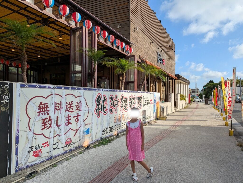 沖縄料理「三線の花」の店舗外観と看板前での記念写真