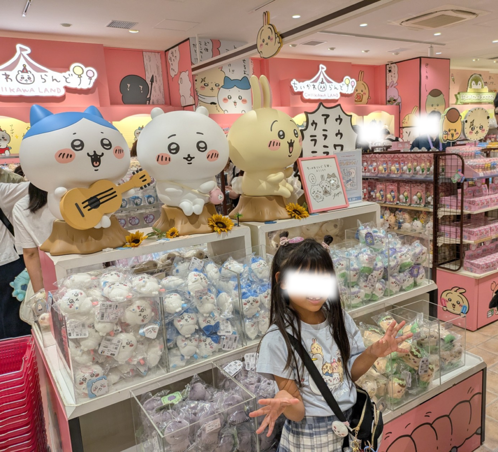 ちいかわランド京都四条河原町店の店内、ハチワレやちいかわたちのフィギュアとたくさんのグッズに囲まれて喜ぶ娘