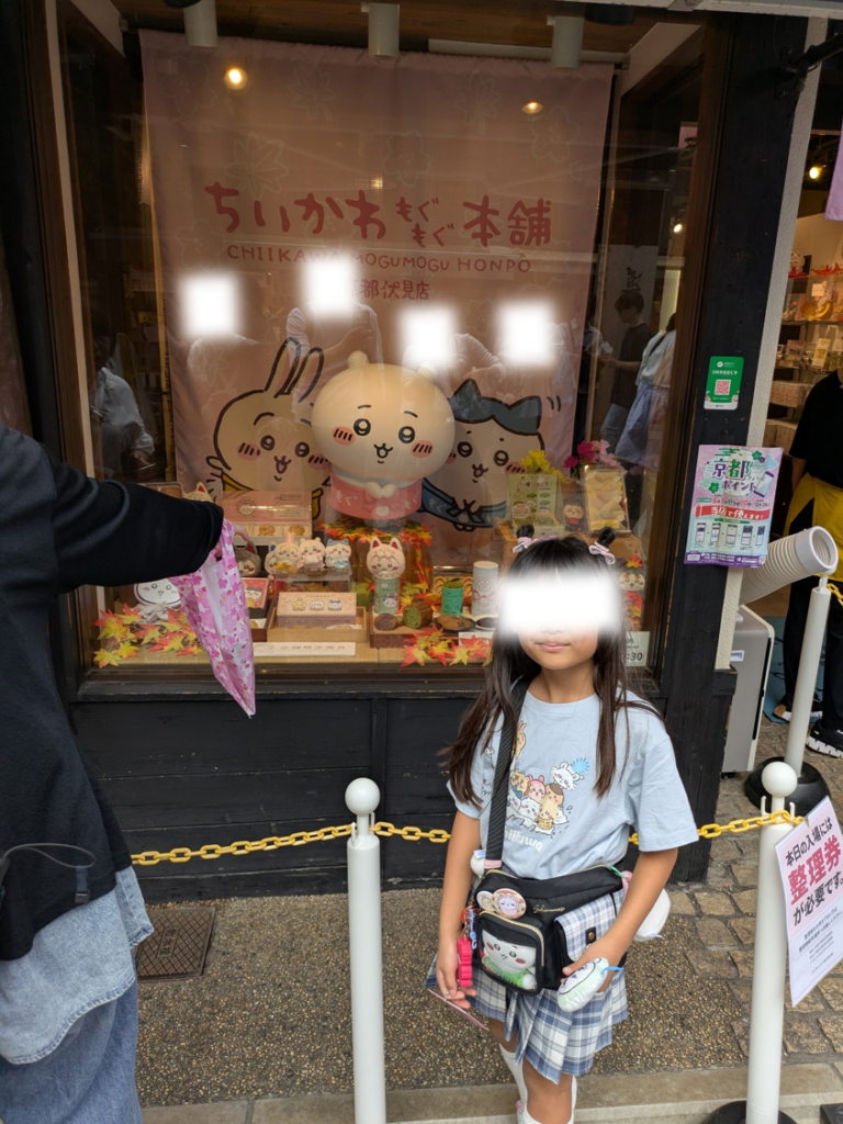 ちいかわもぐもぐ本舗 京都伏見店の入口のちいかわと記念撮影をする娘