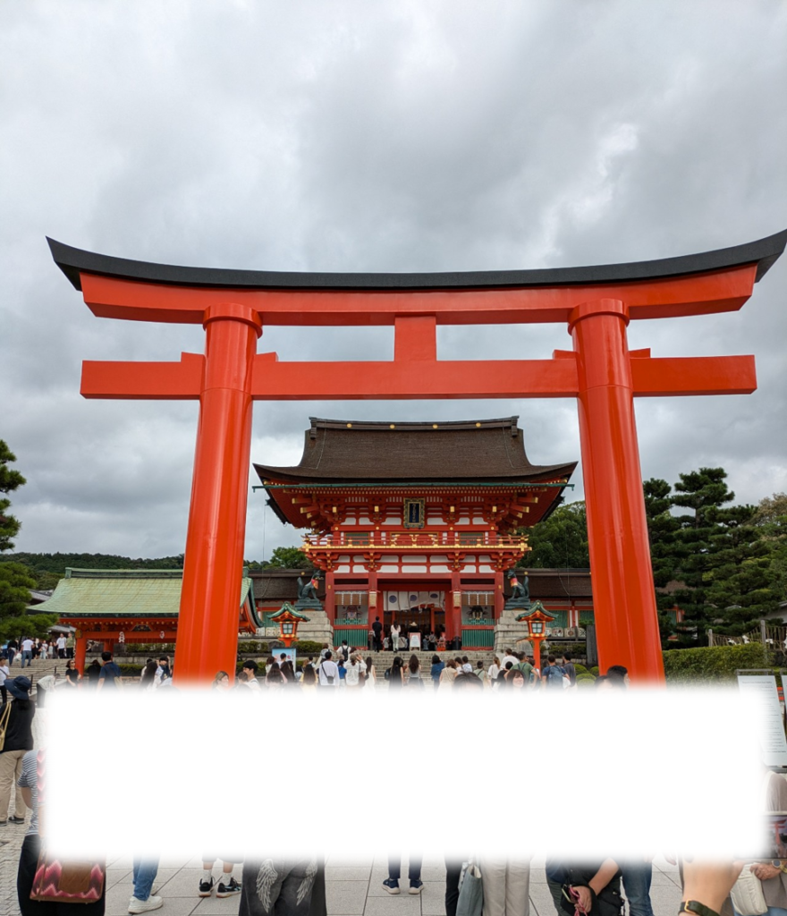 青空と朱色の大きな鳥居が美しい伏見稲荷大社の境内と楼門の風景