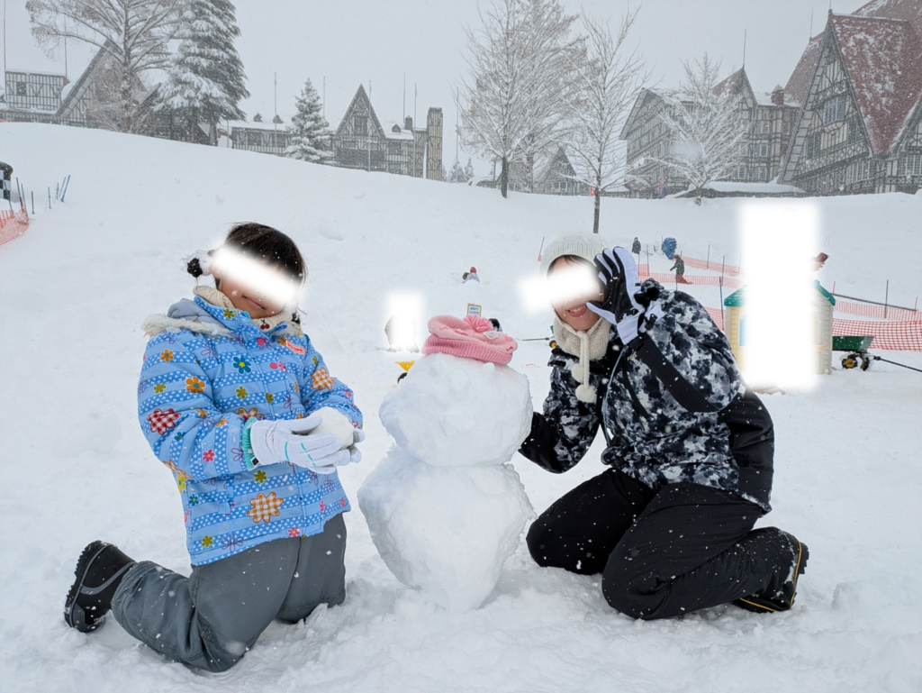 ホテルグリーンプラザ上越前のゲレンデで大きな雪だるまを作って遊ぶ親子