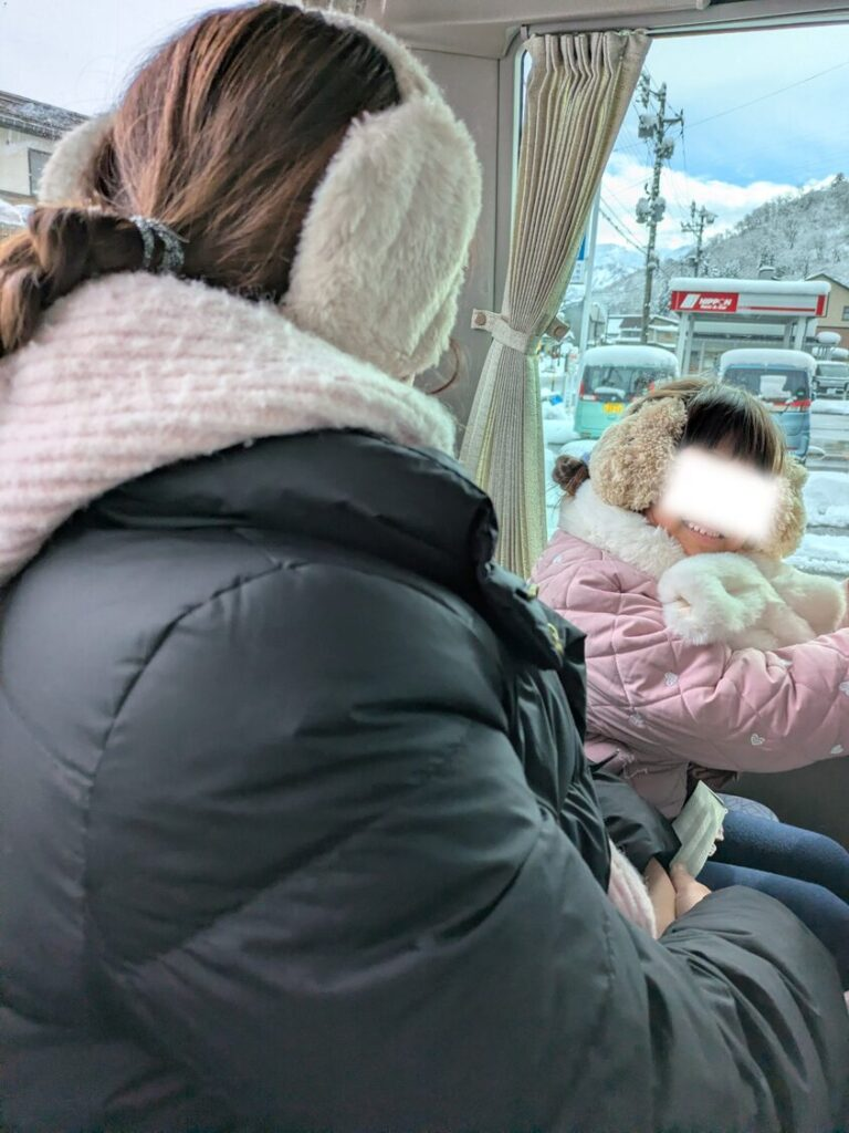 ホテルグリーンプラザ上越へ向かう専用送迎バスの車内と楽しそうに過ごす親子