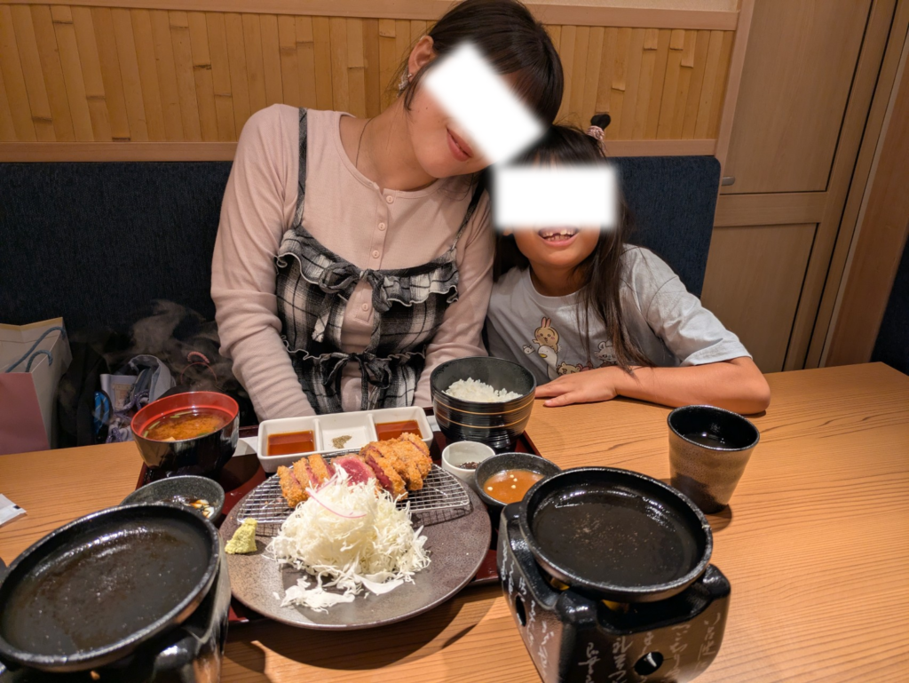 牛カツ京都勝牛 伏見稲荷大社前店で、美味しそうな牛カツ御膳を前に笑顔を見せるママと娘